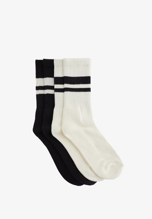 Tre paia di calzini: uno nero, uno bianco e uno a righe bianche e nere. Texture a coste e design alla caviglia. Morbido mix di cotone.