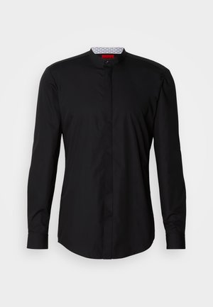 Crna košulja s dugim rukavima i mandarinskim ovratnikom, izrađena od glatkog tkanja, s prednjim dijelom na kopčanje i suptilnim dizajnerskim detaljima.