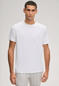 Wit katoenen T-shirt met een ronde hals en korte mouwen. Heeft een minimalistisch ontwerp met subtiele branding op de borst.