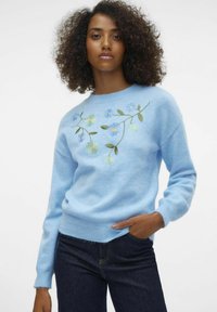 Helles blaues Sweatshirt mit einem bestickten Blumendesign, das gelbe und blaue Blumen zeigt, weicher Textur sowie bündchen und Saum in Rippstrick.