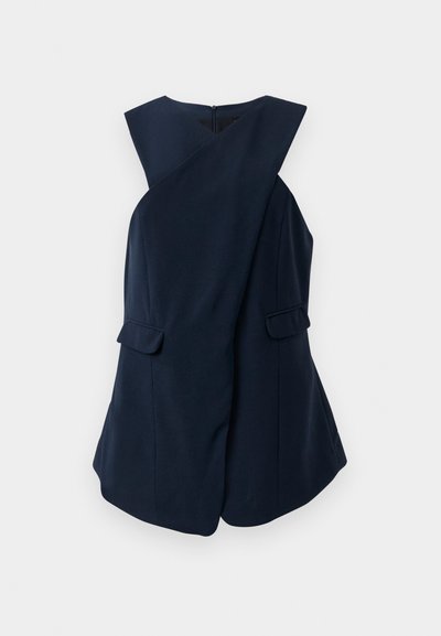 Ärmelloses dunkelblaues Kleid mit einem Wickel-Frontdesign und zwei Klappentaschen, gegenüber einem weißen Hintergrund präsentiert.