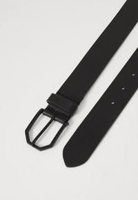 Cinturón de cuero negro con acabado mate, hebilla rectangular de metal negro y varios agujeros de ajuste a lo largo de la correa. Textura suave.
