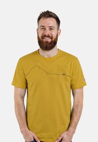 Mosterdgele t-shirt met korte mouwen, voorzien van een zwarte berglijnprint op de borst en een kleine berenafbeelding aan de zijkant.