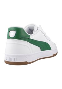 Zapatilla blanca con detalles y marca en verde. Presenta un upper sintético suave, un cuello acolchado y una suela de caucho texturizada.