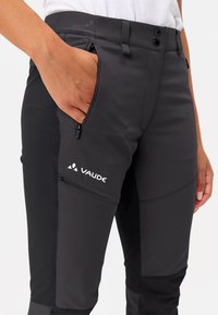 Vaude zwarte outdoorbroeken met een aansluitend ontwerp, ritszakken aan de voorkant, contrasterende panelen en een logo op de dij.