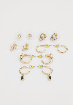 Auskari zeltainā metālā. Ietver divas pāru riņķus ar zaļiem akcentiem un trīs pārus uzlīmes auskarus ar caurspīdīgiem akmeņiem.