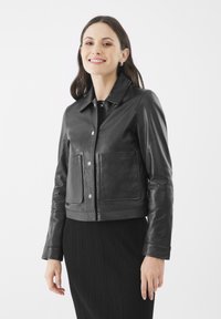Schwarze Lederjacke in cropped Länge mit kragenförmigem Ausschnitt, vorderen Druckknopfverschlüssen und zwei aufgesetzten Taschen. Glatte Textur und taillierte Silhouette.