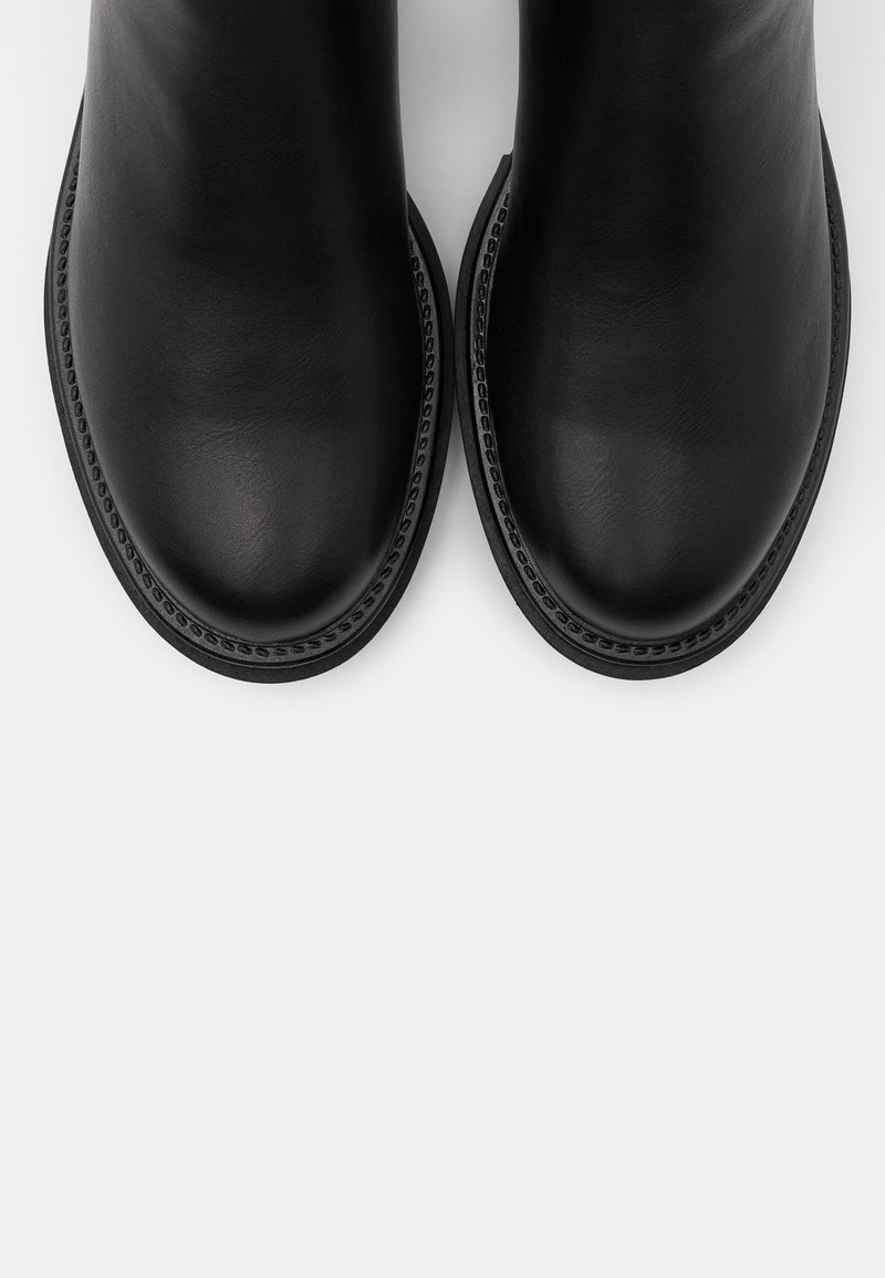 Stivaletti neri in pelle con una finitura liscia, punta rotonda e cuciture a contrasto lungo la suola. Senza hardware o decorazioni visibili.