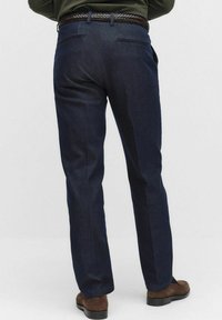 Granatowe spodnie o gładkiej fakturze, prostej linii, z dwiema tylnymi kieszeniami i plecionym brązowym skórzanym paskiem.