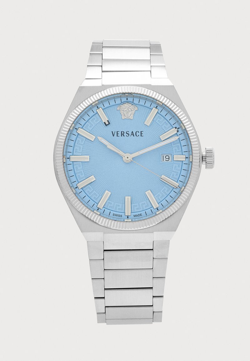 Montre-bracelet en métal argenté avec cadran bleu clair, index horaires argentés, affichage de la date et logo Versace avec tête de Méduse à 12 heures.