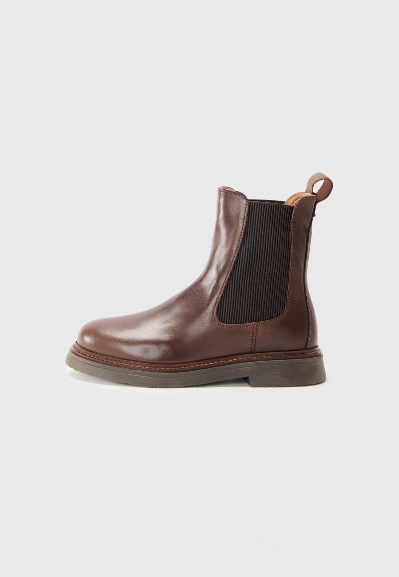 Botte Chelsea en cuir marron avec panneaux élastiques sur les côtés, bout arrondi et texture nervurée. Comprend une languette et une semelle épaisse et durable.