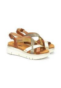 Sandales avec une semelle blanche, dotées d'un dessus en lanières entrelacées de couleurs marron, or et argent. Boucle réglable au niveau du talon.