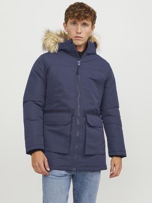 Navy blue parka jacket with fur-lined hood, two front pockets, and zip closure. Made from textured, insulated material. Casual fit.