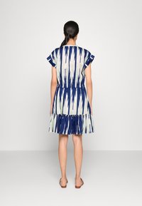 Blue and cream patterned dress with short ruffled sleeves, cinched waist, and flared hemline. Made from lightweight fabric, featuring vertical stripes.