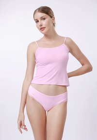 Camisole rose à fines bretelles et culotte bikini assortie agrémentée de dentelle. Le tissu semble doux et léger. Design simple, sans ornement.