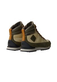 Buty hikingowe z beżową i ciemnozieloną tkaniną górną, pomarańczowymi akcentami oraz wytrzymałą czarną gumową podeszwą. Wzmocniona kostka z wodoodporną tkaniną.