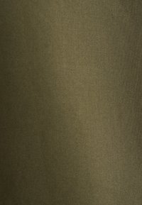 Tissu vert olive avec une texture lisse, affichant une finition mate uniforme et une surface égale sans motifs ni accents visibles.