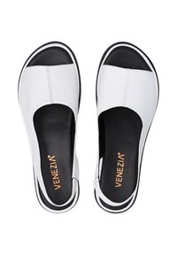 Bílé kožené slip-on boty s černým akcentem na špici, s hladkou texturou a minimalistickým designem. Logo je umístěno uvnitř.