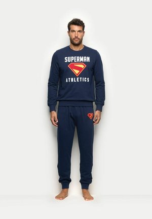 Navyblaues Sweatshirt- und Hosen-Set mit dem Text "SUPERMAN ATHLETICS". Mit einem gelben und roten Superman-Logo. Aus einem Baumwollmischgewebe, lässige Passform.