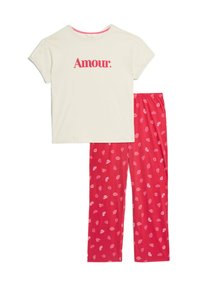 Katoenen pyjama set met een crème top waarop "Amour" staat in het rood en roze-patroon broek met lippenprints op een rode achtergrond.