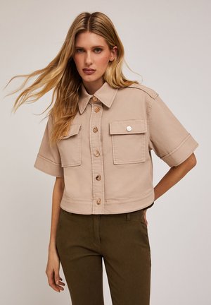 Korte mouwen, cropped beige jas gemaakt van zachte stof, met twee voorzakken, knoopsluitingen en een klassiek kraagontwerp.