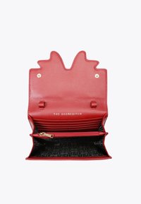 Portafoglio in pelle rossa con un'apertura a scallop unica, hardware in tonalità oro, numerosi slot per carte e una tasca con zip. Tessuto interno a fantasia.