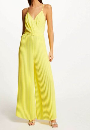 Gul plisseret jumpsuit med dyb V-udskæring, tynde stropper og et matchende bælte i taljen. Flydende materiale og bredbenet design.