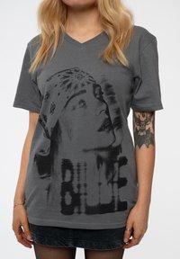 Gray cotton t-shirt with a v-neck, featuring a monochrome graphic of a face and the text "BILLIE" applied in a faded style.