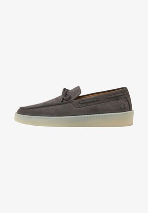 Grauer Wildleder-Slipper mit seitlichem Schnürdetail, abgerundeter Spitze und cremefarbener Gummisohle, von der Außenseite auf weißem Hintergrund gezeigt.