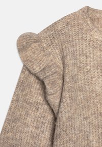 Maglione lavorato a maglia in un taupe chiaro con tessuto testurizzato, caratterizzato da un accento arruffato sulla spalla. Collo rotondo e maniche lunghe.