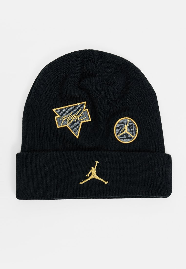 Czarna dzianinowa czapka z daszkiem z złotymi haftowanymi naszywkami, w tym "Flight", okrągłym logo i ikonicznym sylwetką Jumpman.
