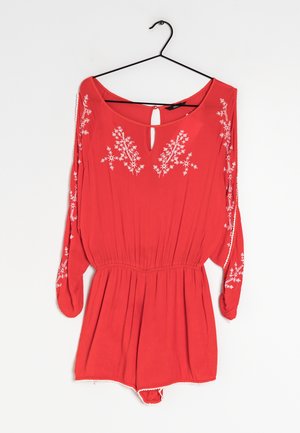 Combinaison rouge à manches longues avec broderies florales. Encolure en forme de trou de serrure, taille élastique, tissu doux et bas court. Étiquette de suspension visible.