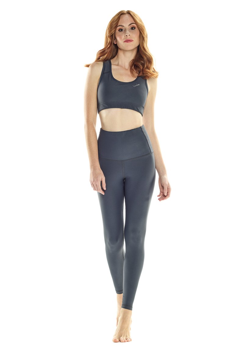 Dunkelgraues sportliches Crop-Top und hochgeschnittene Leggings, hergestellt aus einem glatten Stoff mit einer geschmeidigen Textur und minimalistischem Design, ohne sichtbare Logos.