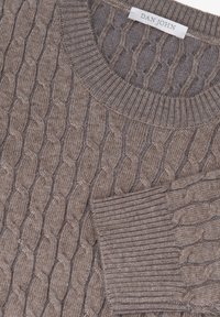Brun strikket sweater med et kabelmønster og ribbet rundt halsen og ved håndleddene. Teksturen er blød med en let blank finish.