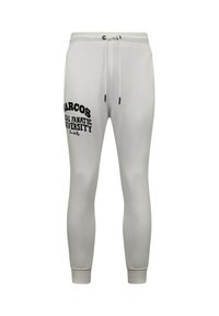 Witte sweatpants met een getailleerd ontwerp, een trekkoord in de tailleband en zwarte opdruk met de tekst "MARCOS", "REAL FANATIC" en "UNIVERSITY" aan de zijkant.