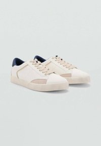 Sneaker beige con una parte superiore in pelle liscia e suede, colletto in contrasto blu navy, lacci piatti e suola in gomma. Design semplice e contemporaneo.