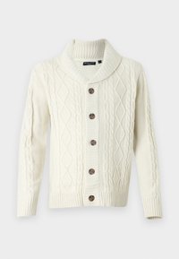 Krämfärgad cable knit kofta med sjalkrage, som har fem bruna knappar och ribbade muddar. Strukturerad mönster genom hela plagget.