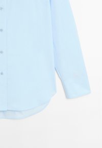 Camicia azzurro chiaro con bottoni, orlo curvo, maniche lunghe e texture del tessuto liscia, con colletto classico e chiusura frontale a bottoni.