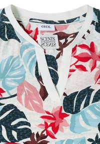 Chemise à col avec col en V et motif floral rouge, bleu, rose et marron. Les étiquettes indiquent "CECIL" et "SCENTS of Salt & Fresh Pine."