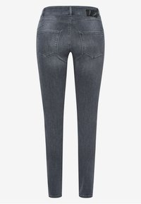 Jean slim gris foncé vu de dos avec deux poches arrière et un petit détail patch noir sur la ceinture.