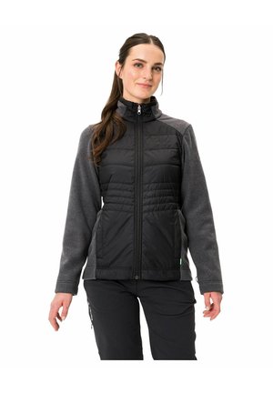 Schwarze und graue Jacke mit durchgehendem Reißverschluss, dick gefüttertem Körper, taillierten Ärmeln und hohem Kragen. Hergestellt aus verschiedenen Stofftexturen.
