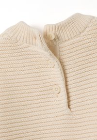 Beige gestrickter Pullover mit geripptem Kragen, der drei Knöpfe an der Knopfleiste und ein strukturiertes, gestreiftes Design aufweist.