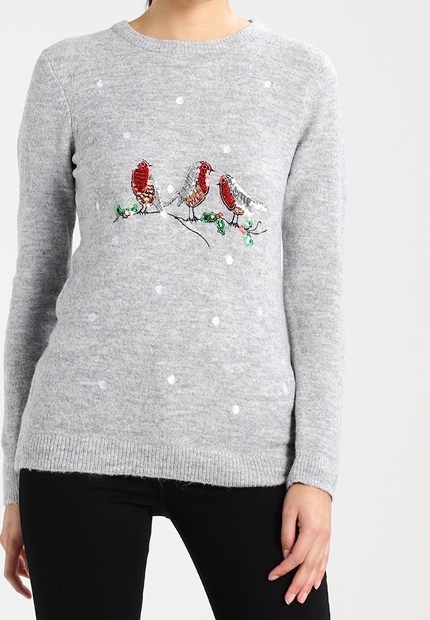 Grå stickad tröja med mönster av vita prickar, som har tre paljettfåglar på en gren och gröna detaljer. Rundad halsringning och ribbad nederkant.