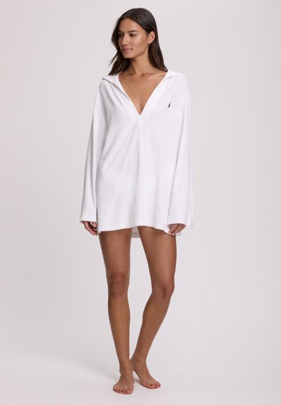 Λευκή κουκούλα με μακριά μανίκια, βαθύ V ντεκολτέ, μαλακή υφή πετσετέ και μικρό λογότυπο στο στήθος.
