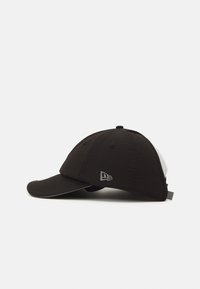 Cappellino da baseball nero con visiera curva, realizzato in tessuto leggero, con un pannello laterale bianco e un logo riflettente sulla parte anteriore.