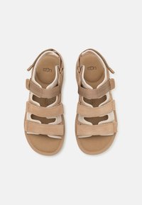 Brune semskede sandaler med justerbare stropper og utskjæringer. Myk innersåle med teksturert fotbed. Slitestyrt såle.