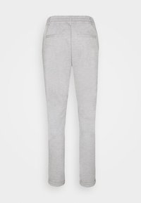 Pantalons de survêtement gris clair en tissu doux, dotés d'une taille élastique et de deux poches arrière, se rétrécissant vers les chevilles avec des ourlets roulés.