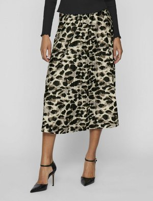 Plissierter Midi-Rock im beige-schwarzen Tiermuster, aus leichtem Stoff gefertigt. Kombiniert mit spitzen schwarzen High Heels.