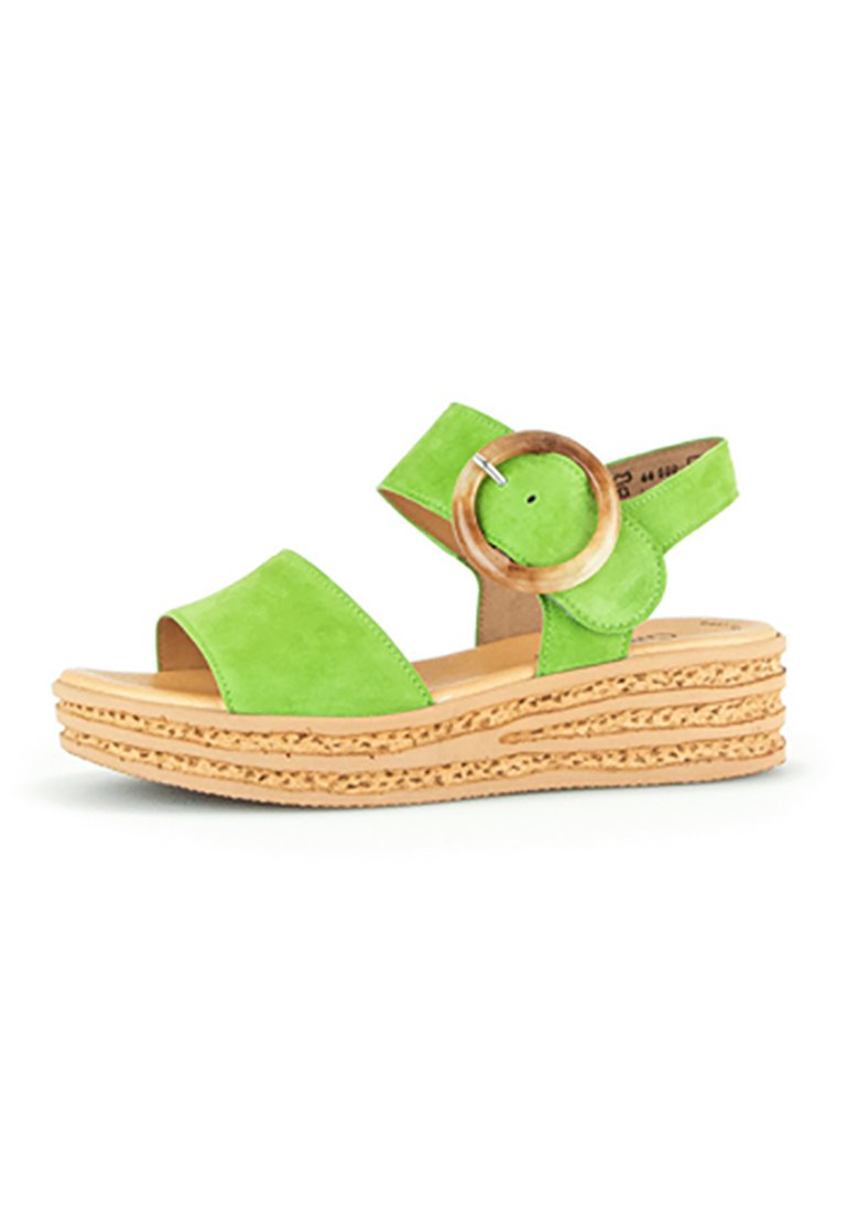 Sandali con zeppa in suede verde, dotati di due cinghie anteriori e un accento a forma di anello in legno. Suola naturale testurizzata con design a strati.