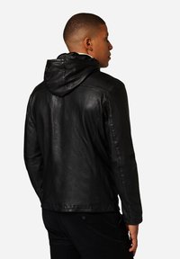 Schwarze Lederjacke mit Kapuze, ausgestattet mit einer glatten Textur und passgenauer Schnittführung, sichtbaren Nähten und einem klassischen Design.